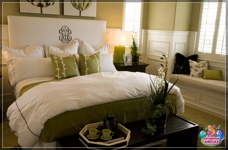 Łóżko w sypialni z biało-zieloną kołdrą i poduszkami