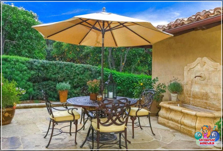 design della casa Patio esterno con fontana d'acqua e tavolino rotondo con ombrellone