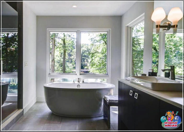 40 idées de design de salle de bain moderne (photos) () Salle de bain principale moderne avec vue sur la fenêtre de la baignoire, vanité sombre et planchers de carreaux de porcelaine