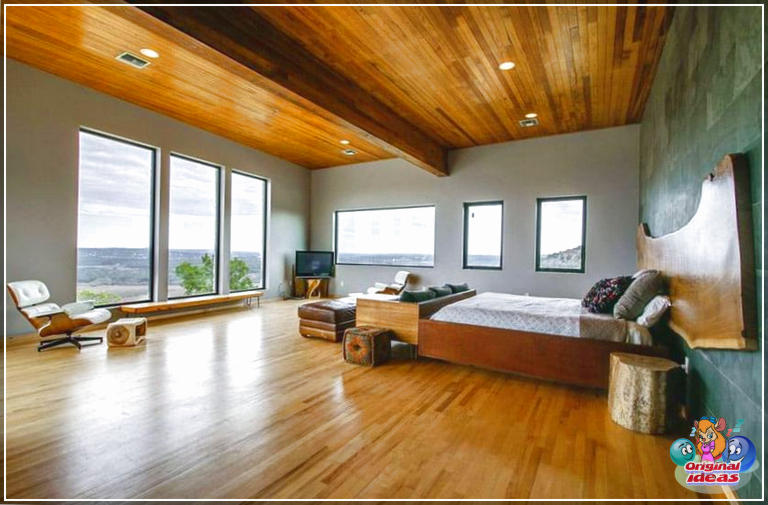 Современная главная спальня с темно-зеленой акцентной стеной и дубовыми полами.