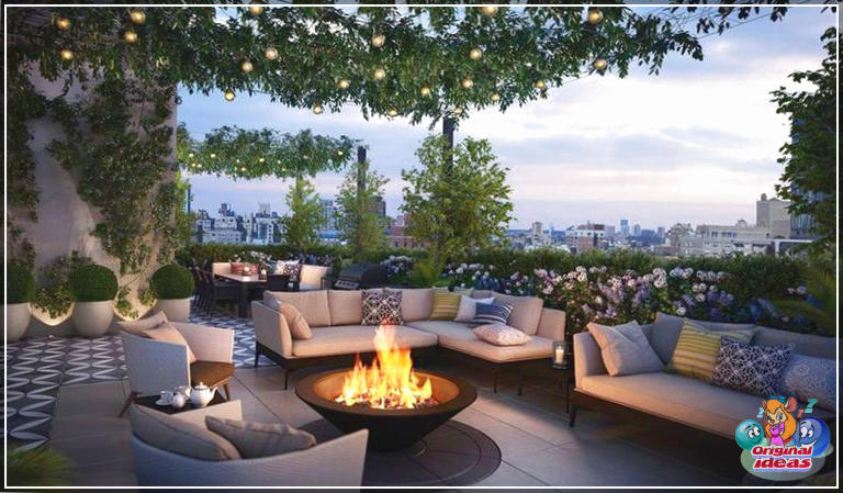 Hermoso patio en la azotea con plantas ajardinadas, muebles de exterior, fogata y vistas a la ciudad